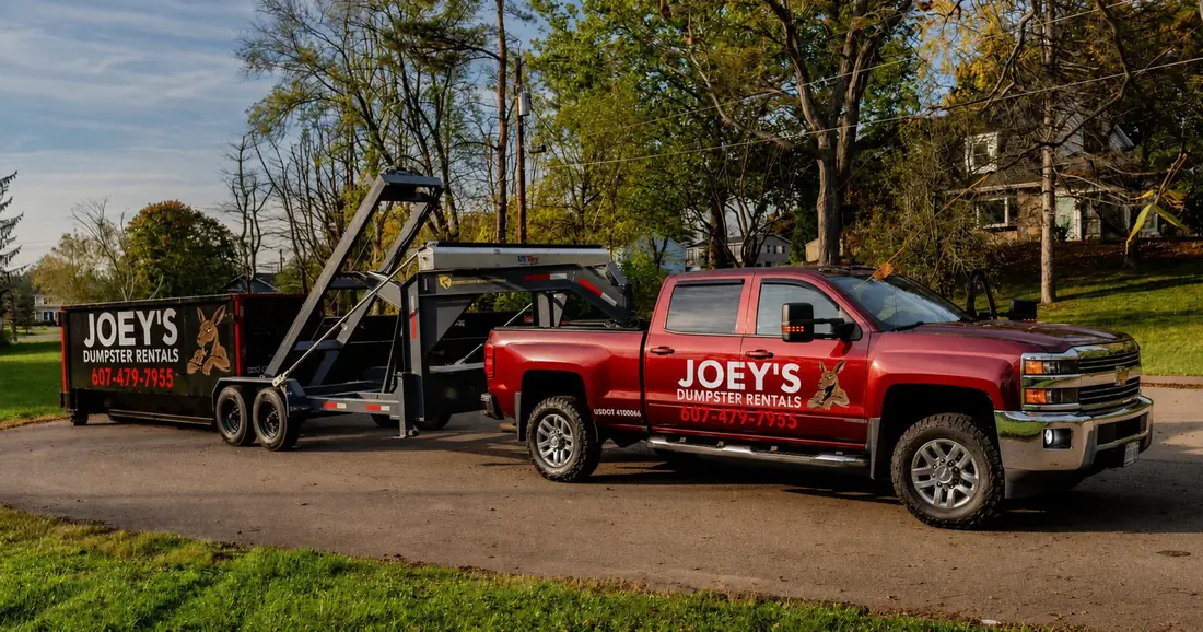 Joey’s Dumpster Rental truck delivering a dumpster