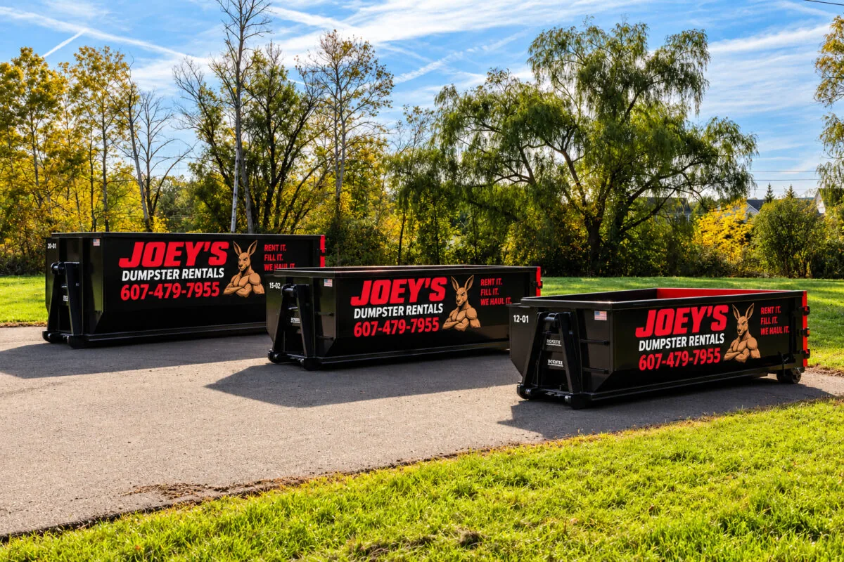 Three black Joey’s Dumpster Rental roll-off dumpsters in 12, 15 and 20 yard sizes